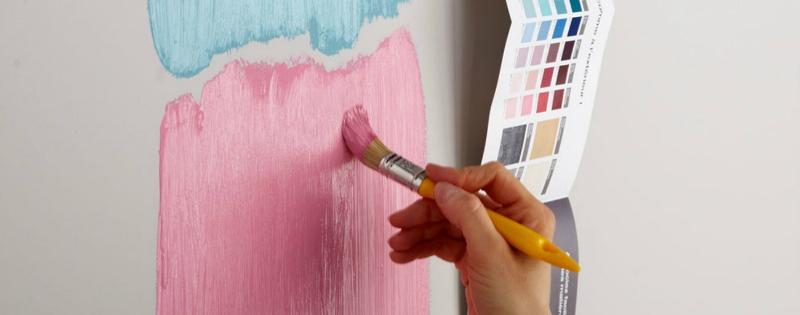 Un rouleau de peinture terracota appliqué sur un mur de chambre avec des gestes précis